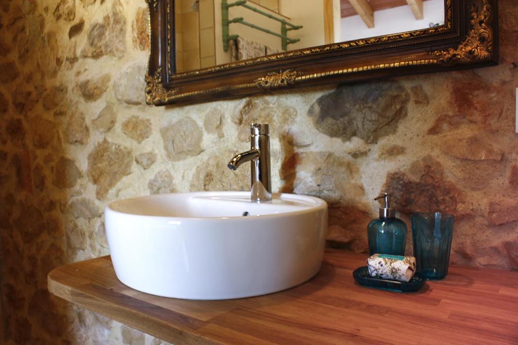 a white sink on a wooden counter with a mirror at Can Elisa in Tárbena