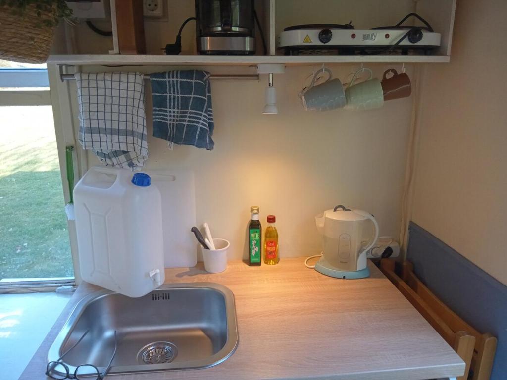a kitchen counter with a sink and a mixer at Heerlijk relaxen, knusse accommodatie vlakbij zwemplas in Vierakker