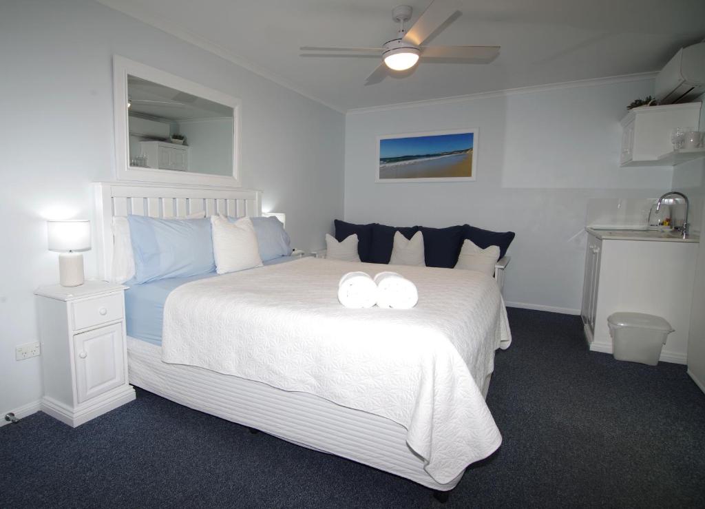 een slaapkamer met een wit bed en 2 witte handdoeken. bij Debbie's Place in Rainbow Beach