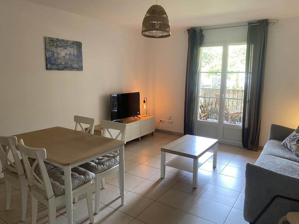 un salon avec une table et un canapé dans l'établissement Les Jasmins, à La Croix-Valmer