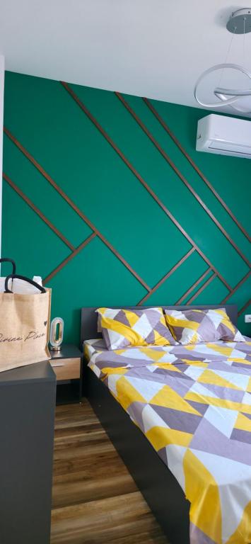 a bedroom with a bed and a green wall at Divine place Pomorie in Pomorie