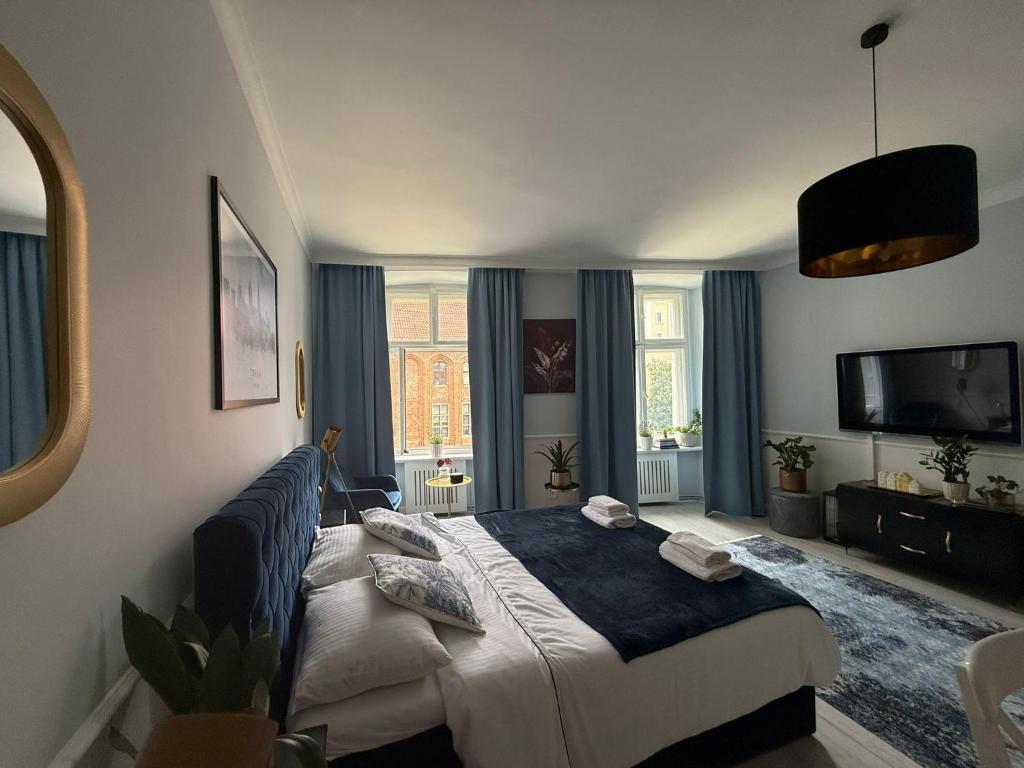 a bedroom with a bed and a television in it at Staromiejska Panorama -Lokalizacja Premium Widok na Rynek Staromiejski in Toruń