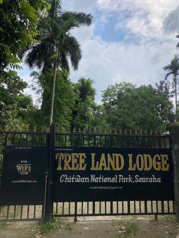 索拉哈Hotel Tree Land Lodge and Cottage的篱笆上的树木土地小屋标志
