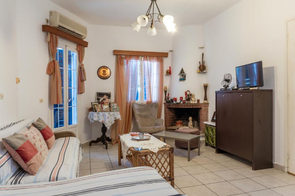 a living room with a couch and a tv at Charmante ferienwohnung in Tinos Town