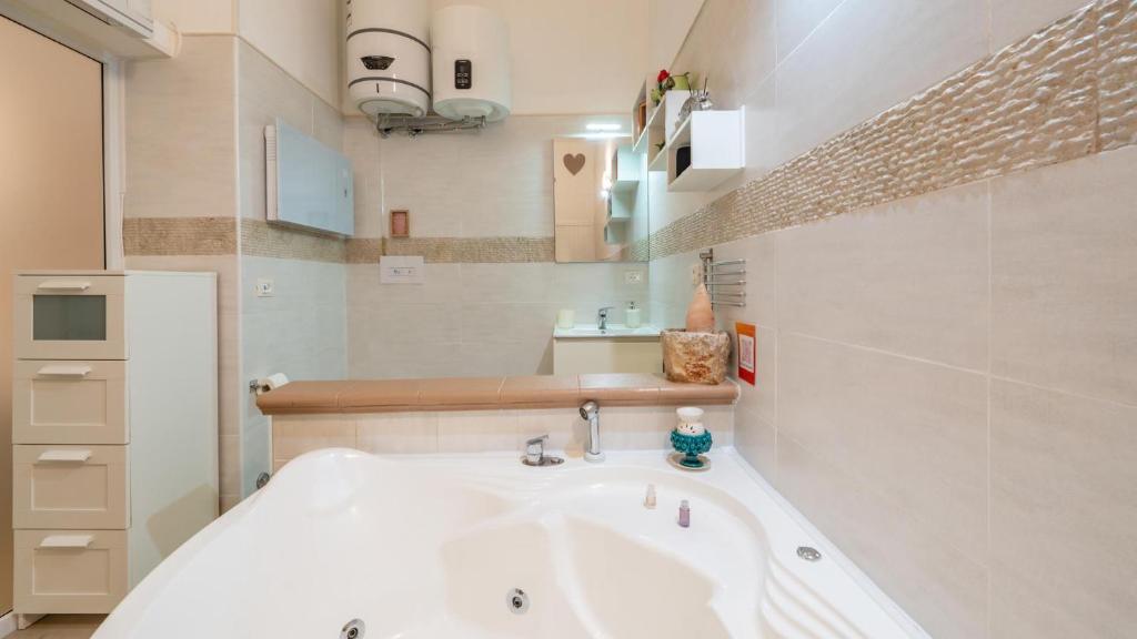 a white bathroom with a tub and a sink at V&M Suite con Jacuzzi by Rentbeat in Ostuni