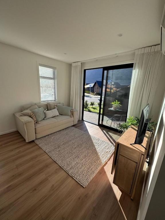 a living room with a couch and a television at One bedroom apartment in Queenstown Airport
