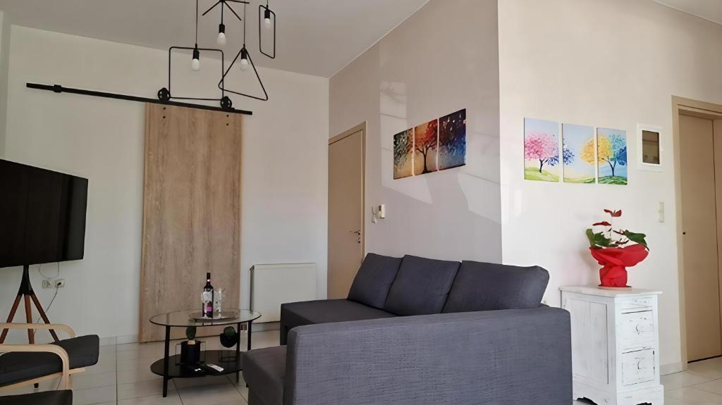 ein Wohnzimmer mit Sofa und Fernseher in der Unterkunft 4Seasonsapts in Agios Nikolaos