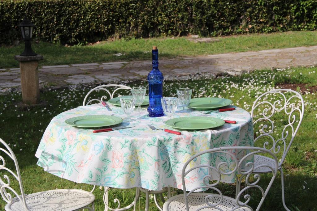 una mesa con platos y una botella de vino. en Villa des Oliviers, en Fontvieille