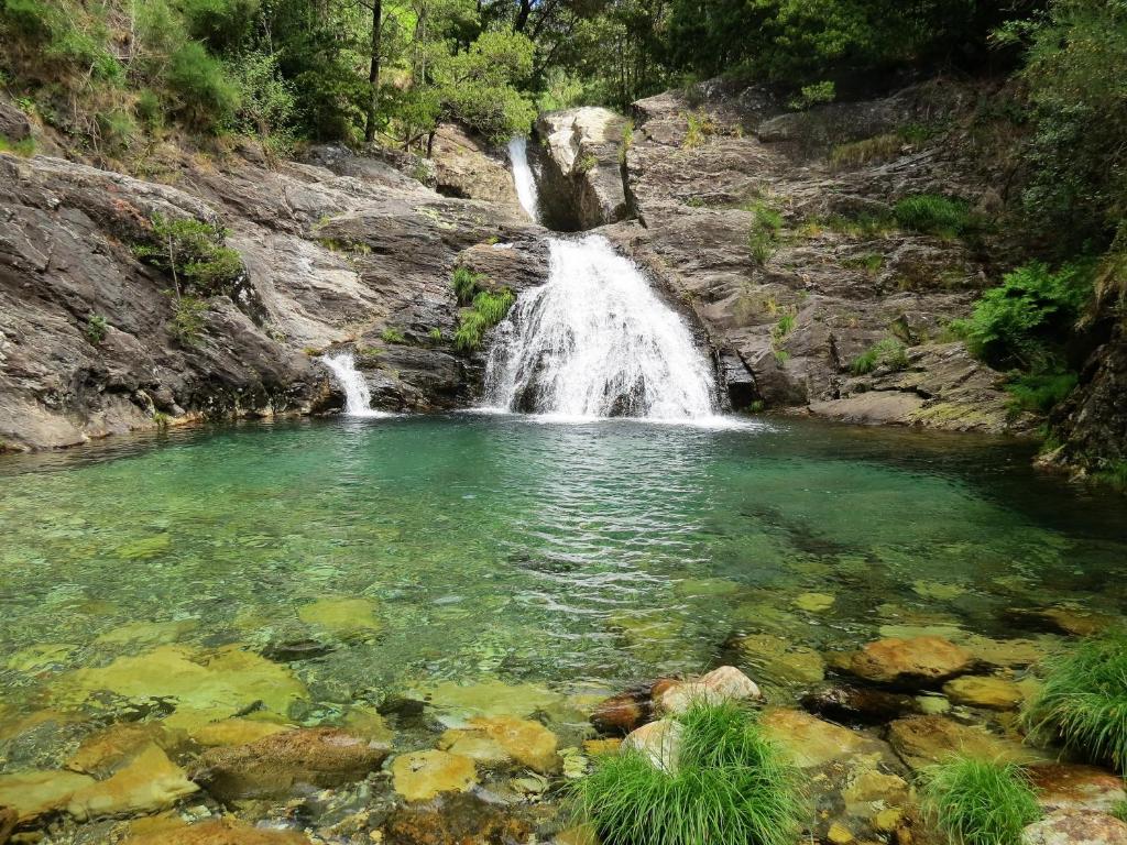 una cascada en medio de una piscina de agua en Serra de Arga Mountain House, en Montaria