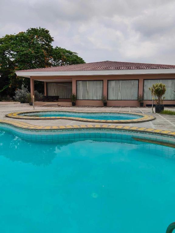 a pool with blue water in front of a building at Poolside Cottage in Lubao