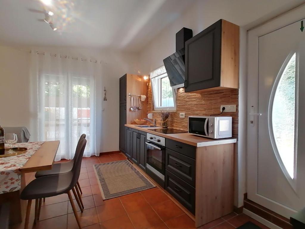 a kitchen with a table and a microwave at Strandnahes Kleines Ferienhaus Mit Terrasse in Šilo