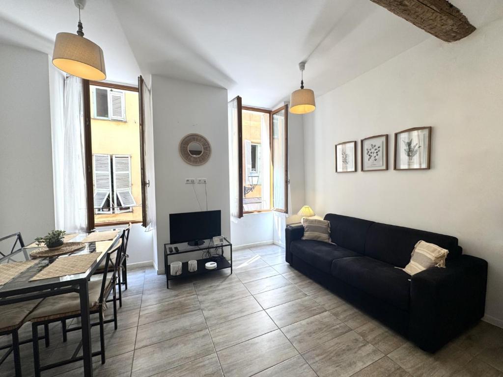 un salon avec un canapé noir et une table dans l'établissement ApartHotel Riviera - Barillerie 12 - Vieille Ville 1mn plage - Appartement 2 pieces AC, à Nice
