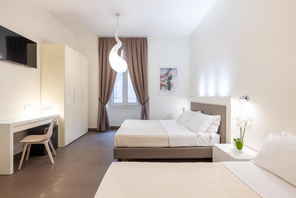 a hotel room with two beds and a desk at Maison Trevi in Rome