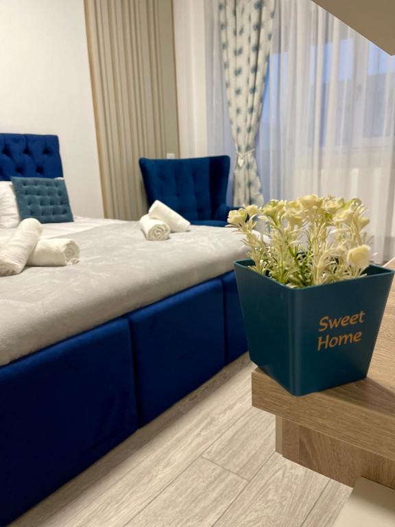 a blue bed with a blue couch and a potted plant at Q Elegance Palas Mall in Iaşi