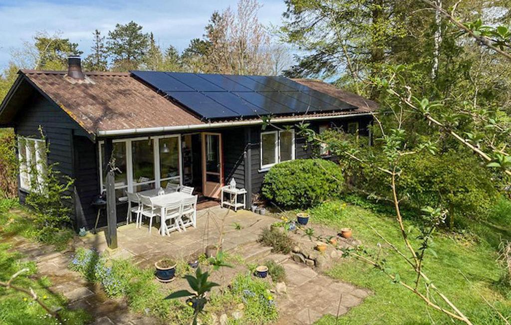 a small house with a solar roof with a patio at Awesome Home In Fårevejle With Kitchen in Fårevejle