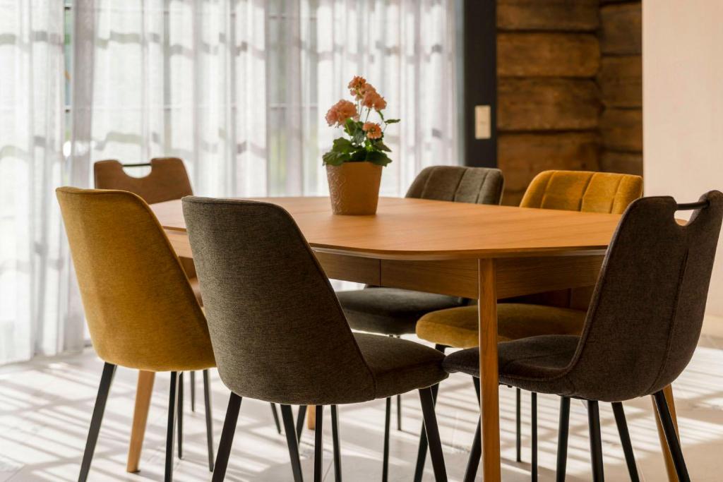una mesa de madera y sillas con un jarrón en la parte superior en Test, en Salacgrīva