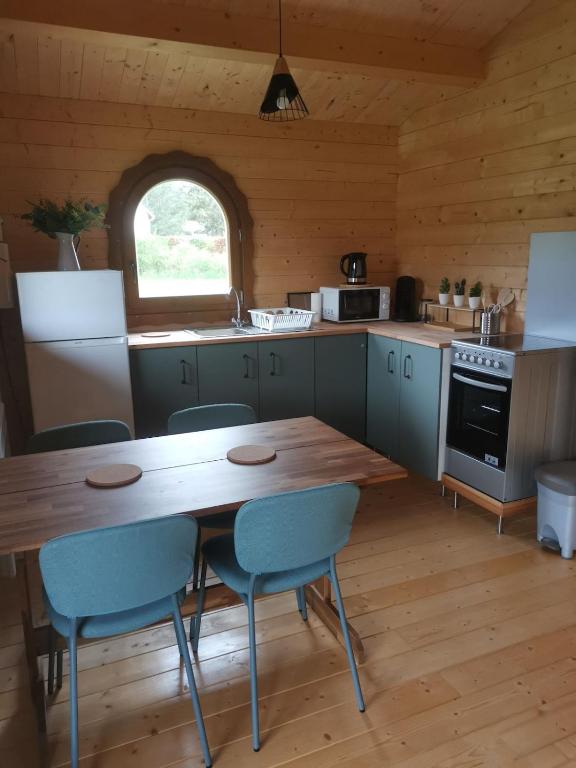 a kitchen with a wooden table and chairs in a cabin at Chalet 4 personnes en Sologne in Neung-sur-Beuvron