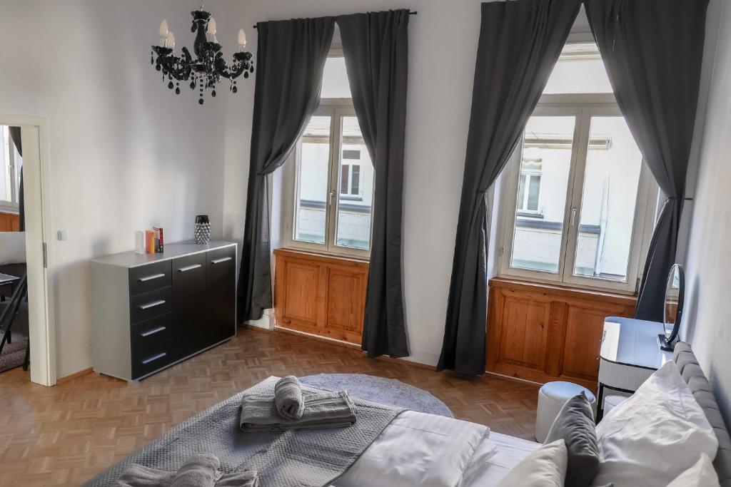 Un dormitorio con una cama y dos grandes ventanales. en EMA Exclusive Locations GmbH, en Limburg an der Lahn