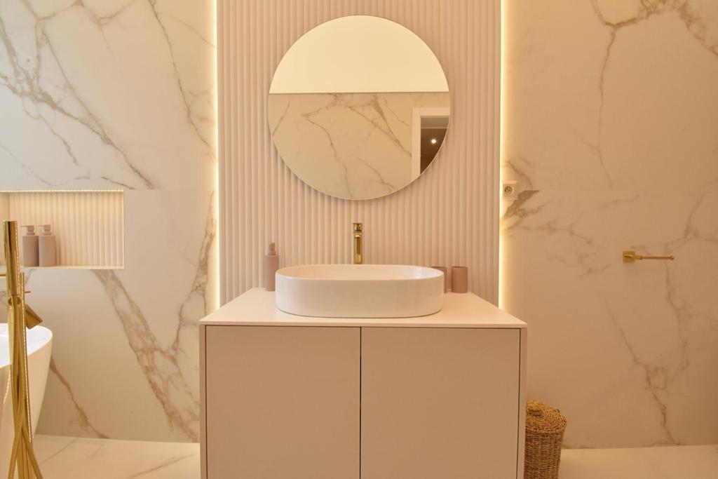 Un baño blanco con lavabo y espejo. en GOLD Apartment, en Rajecké Teplice