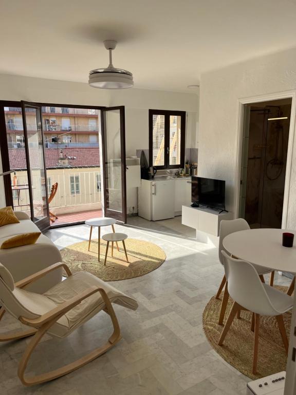 un salon avec une table et des chaises dans l'établissement Studio lumineux et spacieux avec balcon proche Garibaldi, à Nice
