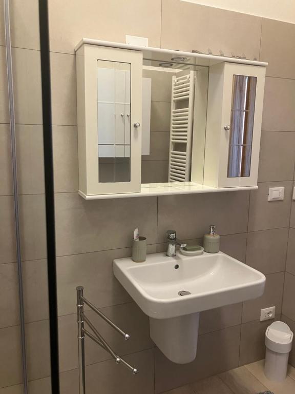 une salle de bains avec un lavabo blanc et un miroir dans l'établissement Apartment, à San Felice del Benaco