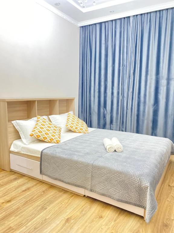 een slaapkamer met een bed met twee witte handdoeken erop bij 2комн Барыс Арена in Astana