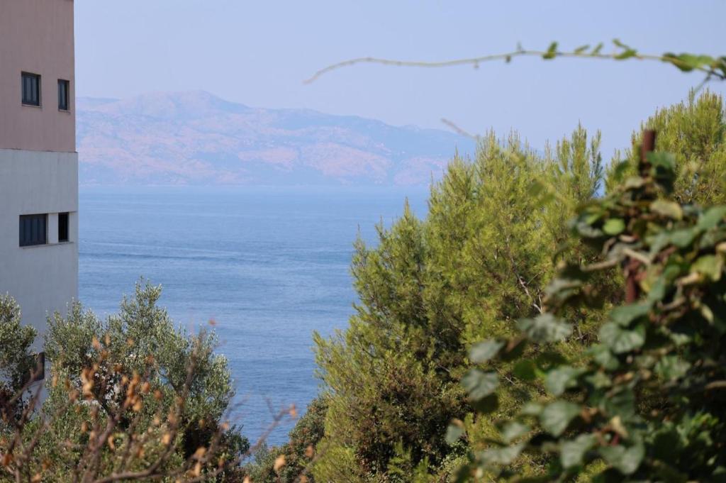 a view of the ocean and a lighthouse at A&K Apartments in Sarandë