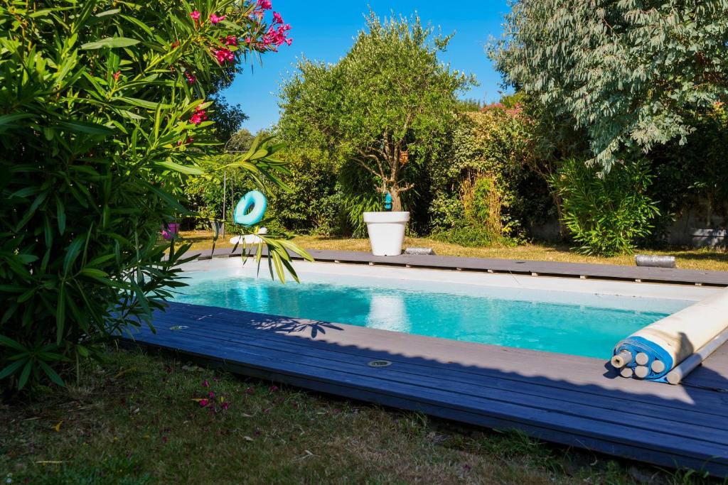 a swimming pool in a yard with a garden at Studio 2-3 personnes piscine partagée in Château-dʼOlonne