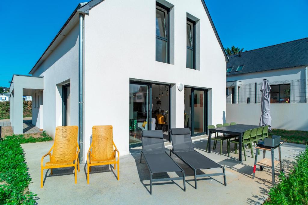 a patio with chairs and a table in front of a building at Maison HG - Presqu'ile de Crozon in Plomodiern