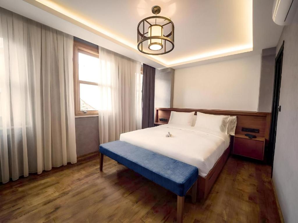 Un dormitorio con una cama grande con un banco azul. en Blu Hotel, en Estambul