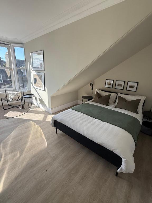 a bedroom with a large bed and a large window at Park House Rooms - Sky TV and kitchenette in Aberdeen