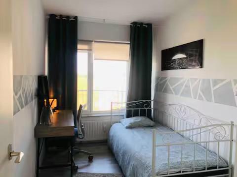 Un dormitorio con una cama y un escritorio y una ventana. en Ladies only! neat cozy room, great loc in Schiedam, en Schiedam