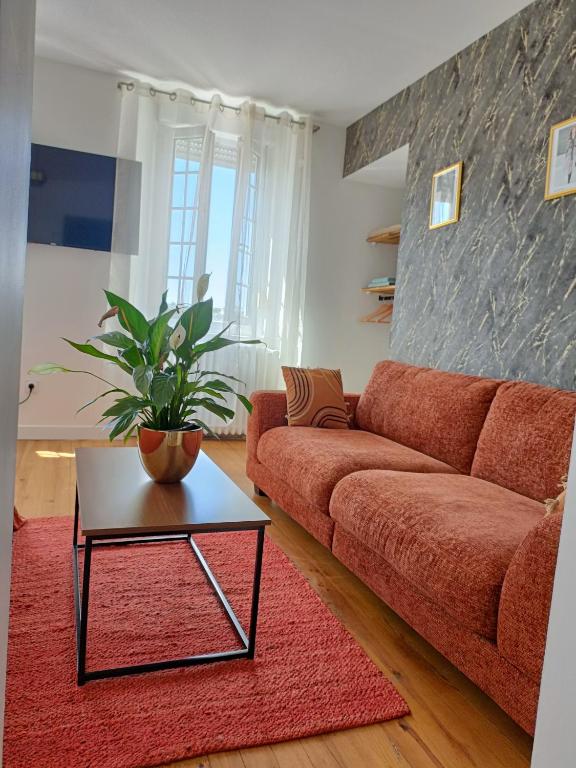 un salon avec un canapé rouge et une table dans l'établissement De Beauvais à Paris, à Beauvais