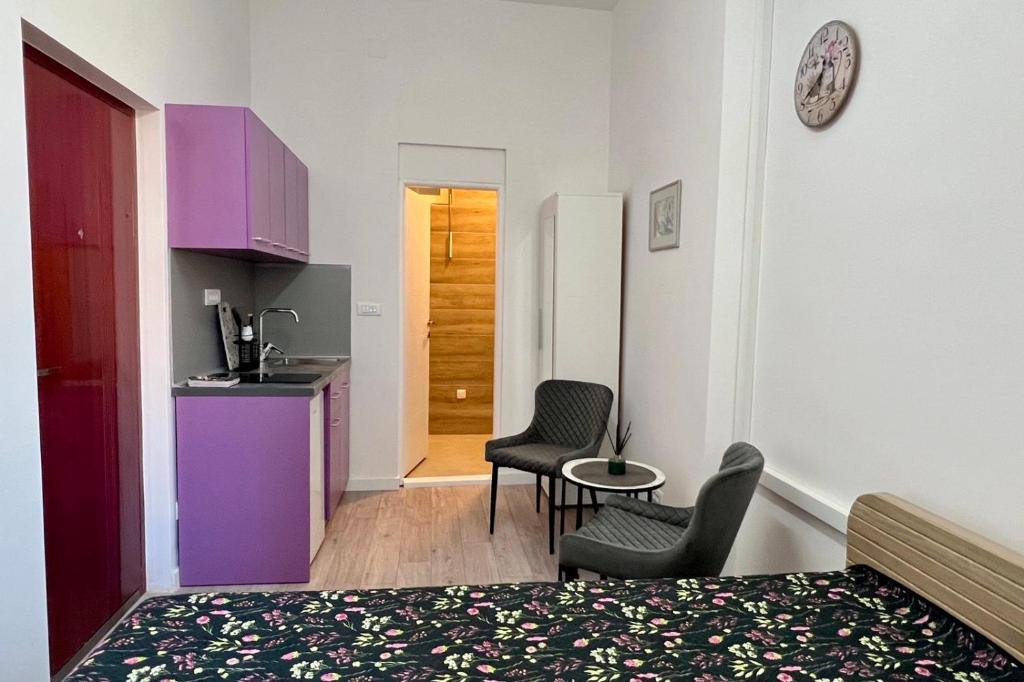 a room with a bed and two chairs and a kitchen at The Bell Studio in Sarajevo