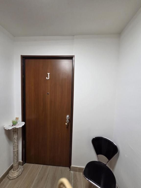 a room with a wooden door and two black chairs at Bellavista Monolocale in Foligno