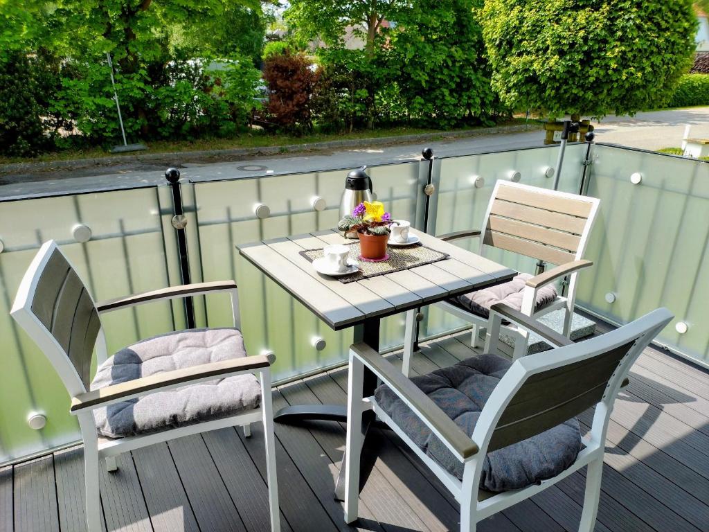 a table and two chairs on a deck with a table and chairs at Aquamarin Ostseetraumsuite 05 in Neuhaus