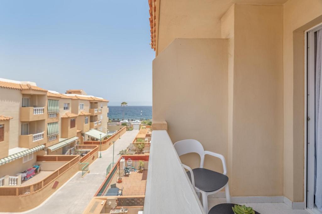 a balcony with chairs and a view of the ocean at Apartamento Afirama 1 in Araya