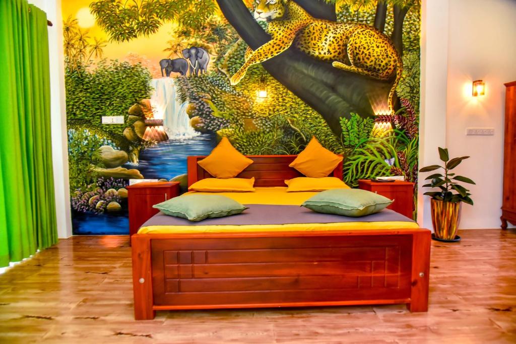 a room with a bed in front of a mural at Villa Green Smile in Aluthgama