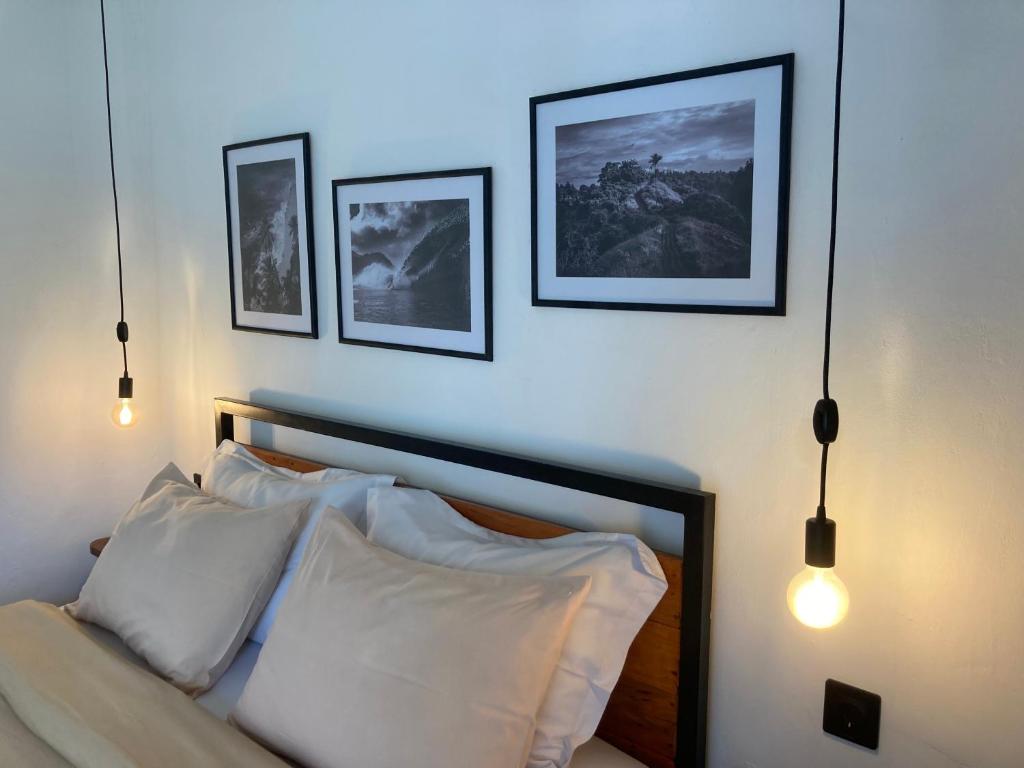 a bedroom with a bed with three pictures on the wall at Rebels Point in Jimbaran