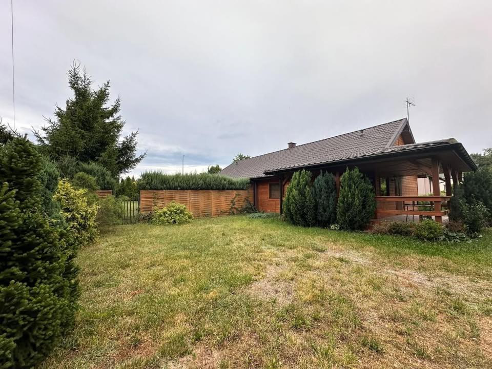 a wooden house with a yard in front of it at Noclegi na Szczęśliwej 1 w Okunince in Okuninka