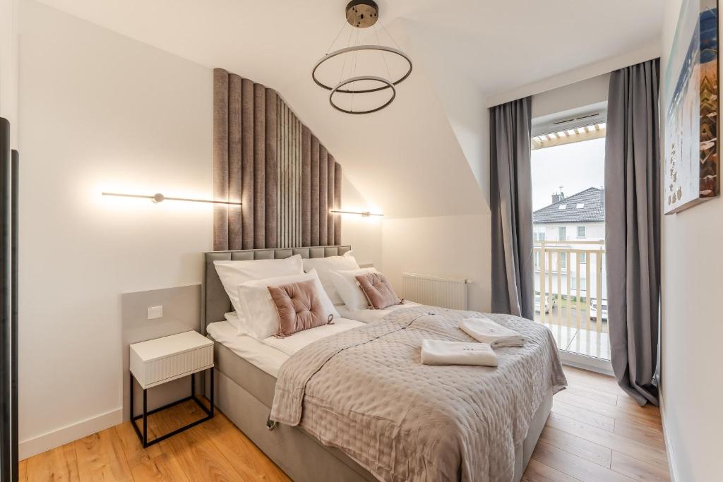 a bedroom with a large bed and a window at Sunday Resort Ustronie Morskie in Ustronie Morskie