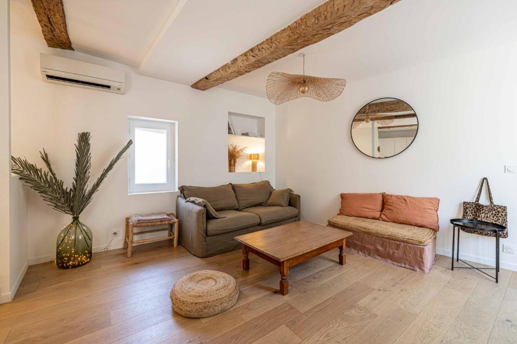 un salon avec un canapé et une table dans l'établissement L'EMERAUDE duplex confortable au cœur de Cannes, proche plage du Midi et Palais, à Cannes