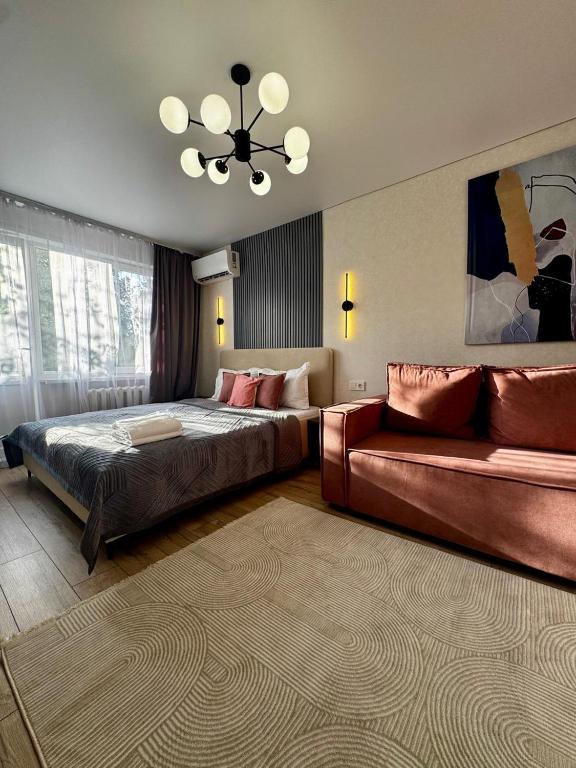 a hotel room with a bed and a couch at Квартира - Терракота in Ustʼ-Kamenogorsk