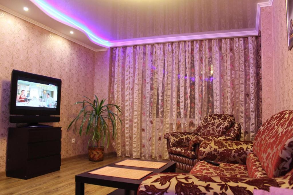 a living room with a couch and a tv at Apartment on Chkalova in Maykop