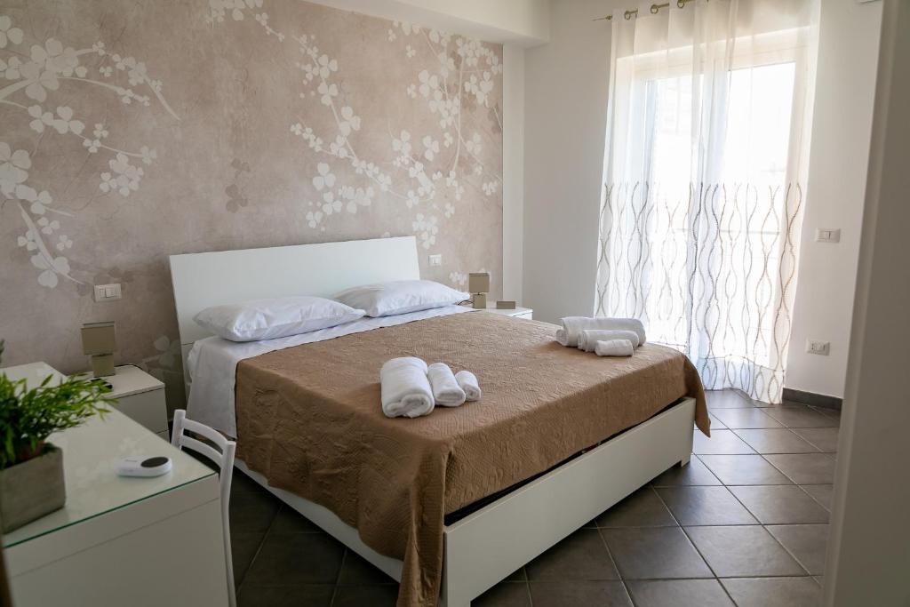 a bedroom with a bed with towels on it at Mare Blu in Giardini Naxos