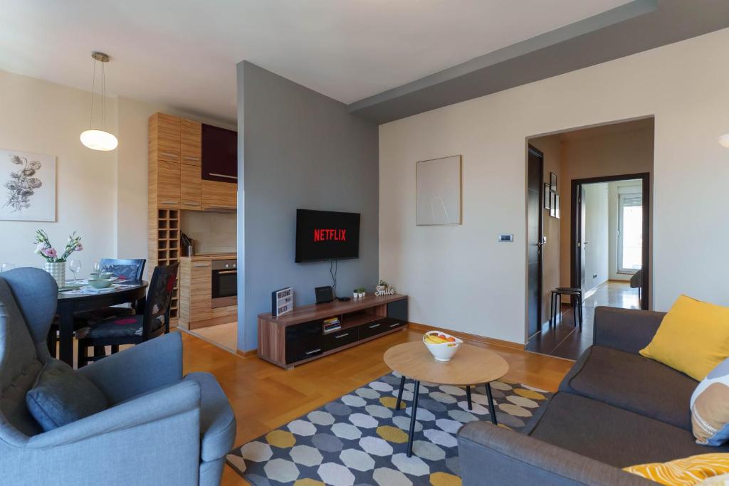 a living room with two blue couches and a table at Belgrade Central QUINCE Apartment in Belgrade