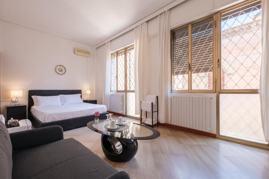 a bedroom with a bed and a couch and a table at Cristina Rossi Bed&Breakfast in Bologna