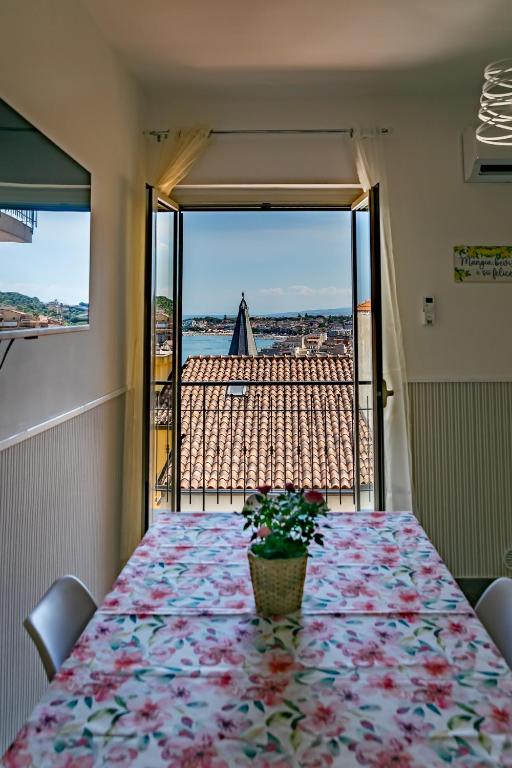 a table with a pot of flowers on it with a view at Mare Blu in Giardini Naxos
