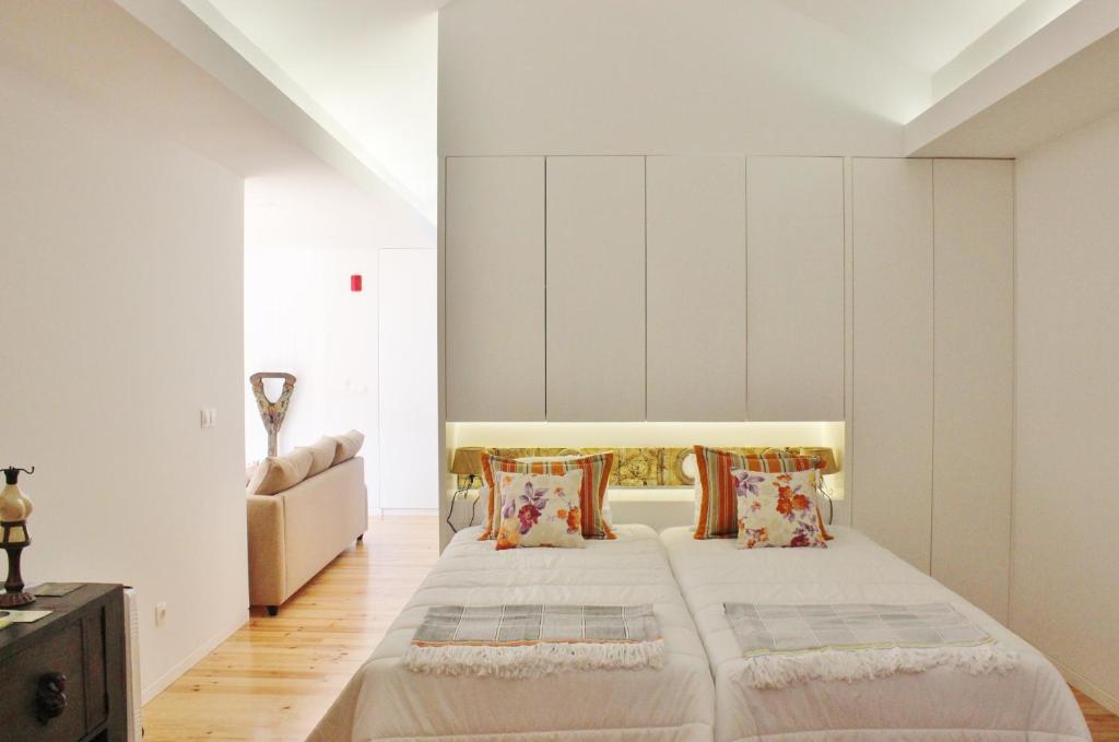 a bedroom with a large bed with white walls at Aldeia do Priolo in Nordeste