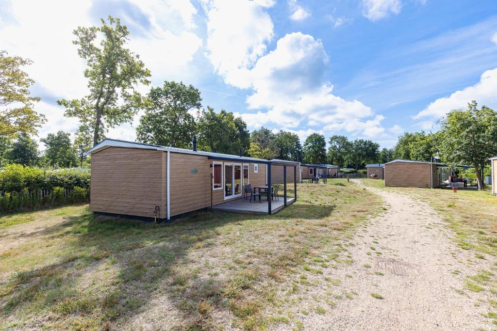 a small cabin in the middle of a field at Welcome in - Chalet Bosdier, Camping de Duinhoeve Burgh-Haamstede in Burgh Haamstede